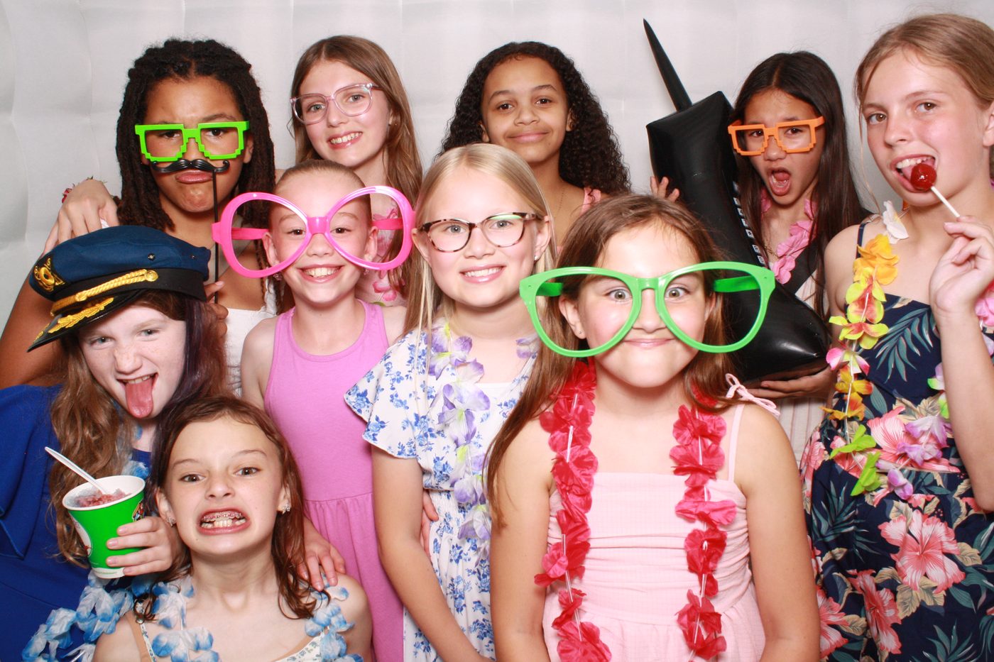 Kids having fun with props in the FaceBooth photo booth at a birthday party